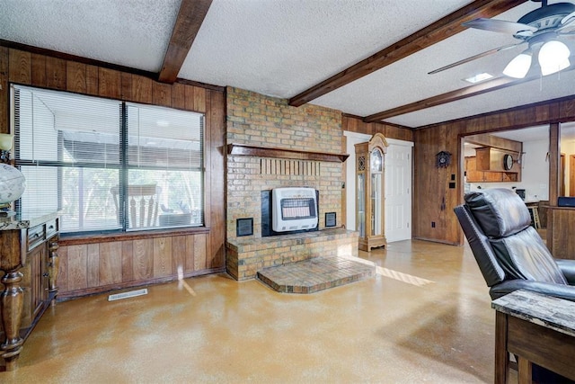 living room featuring wood walls, heating unit, beam ceiling, a textured ceiling, and ceiling fan