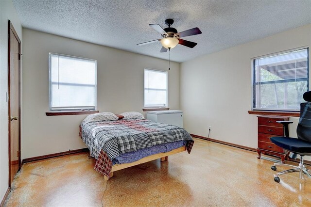 bedroom featuring baseboards, a ceiling fan, and a textured ceiling