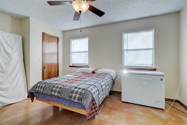 bedroom with a textured ceiling, a ceiling fan, and refrigerator
