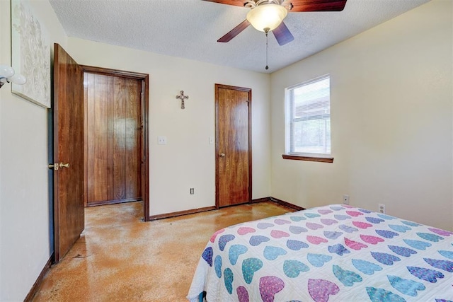 bedroom featuring a ceiling fan, baseboards, a textured ceiling, and light colored carpet