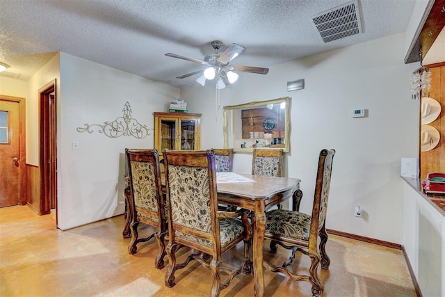 dining space with a textured ceiling, visible vents, and finished concrete flooring