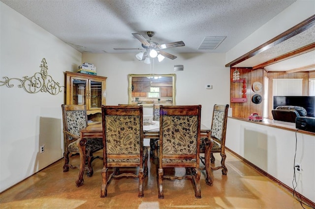 dining space with a ceiling fan, a textured ceiling, visible vents, and finished concrete flooring