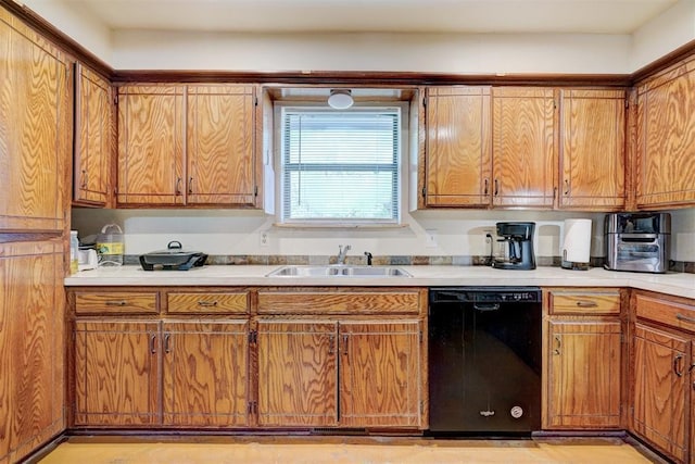 kitchen featuring brown cabinetry, dishwasher, light countertops, and a sink