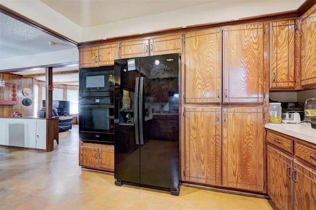 kitchen featuring brown cabinets, black appliances, and finished concrete flooring