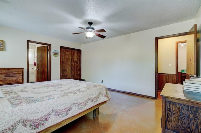 bedroom featuring a textured ceiling, baseboards, ceiling fan, and ensuite bathroom