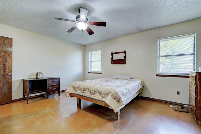 bedroom with baseboards, a ceiling fan, concrete flooring, and a textured ceiling