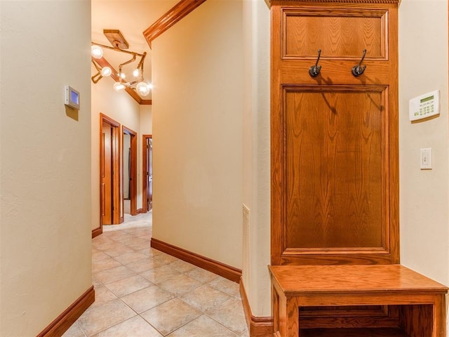 3116 Sycamore Dr, Moore, OK 73160 - corridor featuring light tile patterned floors, crown molding, a notable chandelier, and baseboards