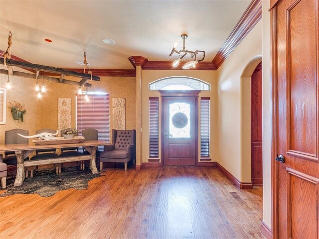 3116 Sycamore Dr, Moore, OK 73160 - foyer entrance with baseboards, arched walkways, ornamental molding, wood finished floors, and a notable chandelier