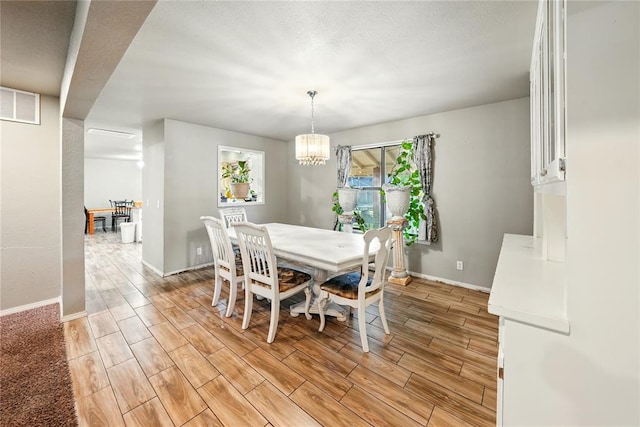 5029 NW 24th Pl, Oklahoma City, OK 73127 - dining room featuring baseboards, a chandelier, visible vents, and light wood-style floors