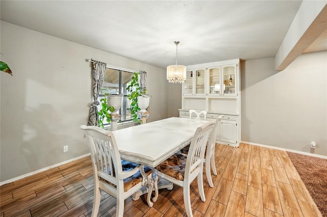 5029 NW 24th Pl, Oklahoma City, OK 73127 - dining space with light wood-style floors, baseboards, and a notable chandelier
