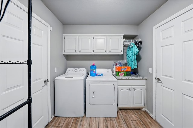 5029 NW 24th Pl, Oklahoma City, OK 73127 - laundry area with washer and clothes dryer, light wood-style floors, and cabinet space