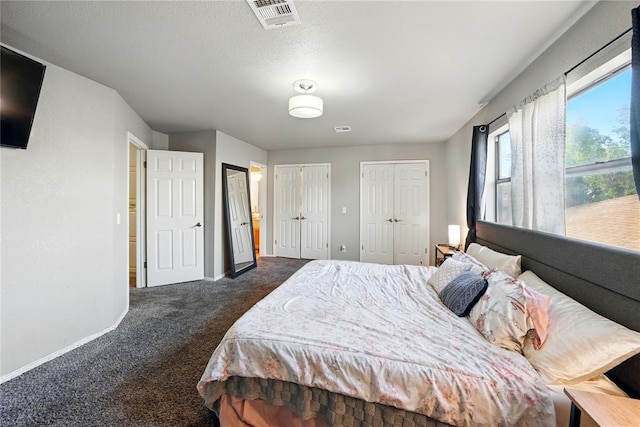 5029 NW 24th Pl, Oklahoma City, OK 73127 - bedroom featuring baseboards, multiple closets, visible vents, and dark carpet