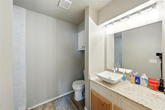 5029 NW 24th Pl, Oklahoma City, OK 73127 - bathroom featuring toilet, vanity, wood finished floors, and visible vents
