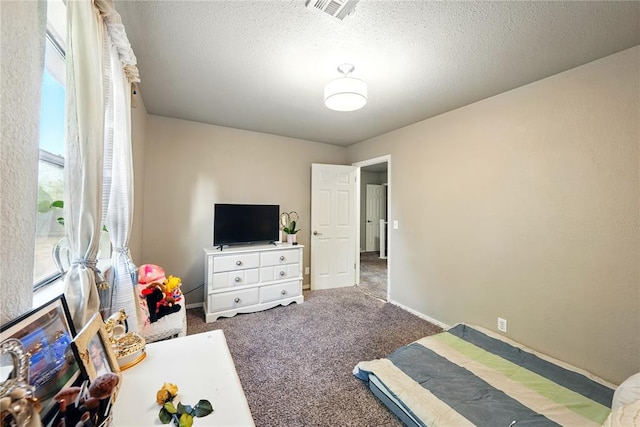 5029 NW 24th Pl, Oklahoma City, OK 73127 - carpeted bedroom featuring baseboards, a textured ceiling, and visible vents