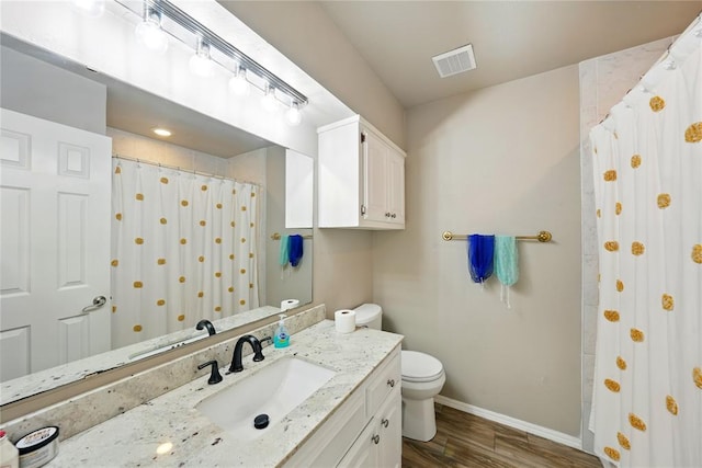 5029 NW 24th Pl, Oklahoma City, OK 73127 - bathroom featuring wood finished floors, visible vents, toilet, vanity, and baseboards