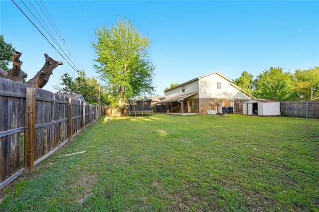 5029 NW 24th Pl, Oklahoma City, OK 73127 - view of yard with an outdoor structure, a trampoline, a shed, and a fenced backyard