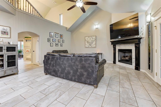 43855 Hunters Hill Dr, Shawnee, OK 74801 - living room featuring a ceiling fan, arched walkways, a glass covered fireplace, high vaulted ceiling, and baseboards