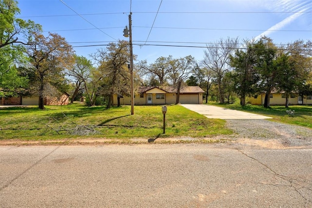 view of front of house featuring a garage, a front lawn, and concrete driveway