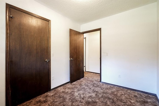 unfurnished bedroom featuring carpet floors, a closet, a textured ceiling, and baseboards