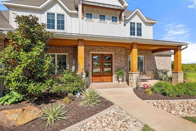 property entrance with covered porch, french doors, brick siding, and board and batten siding