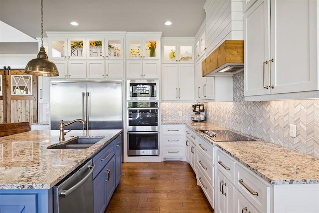 kitchen featuring a sink, pendant lighting, white cabinets, built in appliances, and blue cabinetry