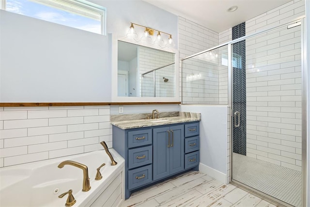bathroom with a tub with jets, vanity, marble finish floor, and a shower stall