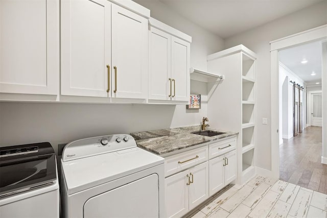 washroom featuring washing machine and dryer, recessed lighting, light wood finished floors, a sink, and cabinet space