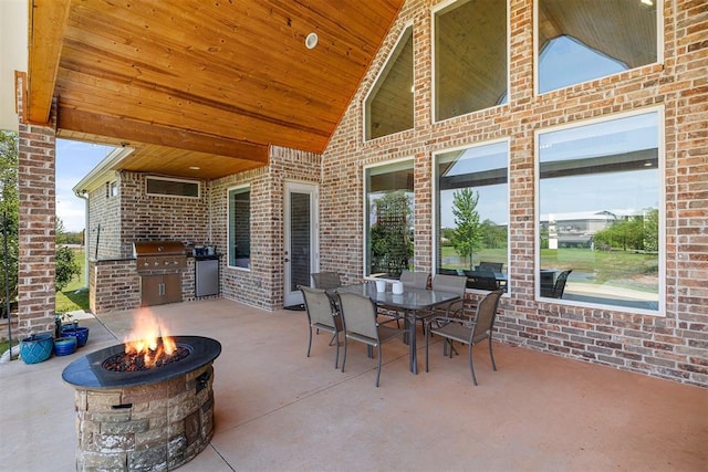 view of patio with an outdoor fire pit, outdoor dining space, a grill, and area for grilling