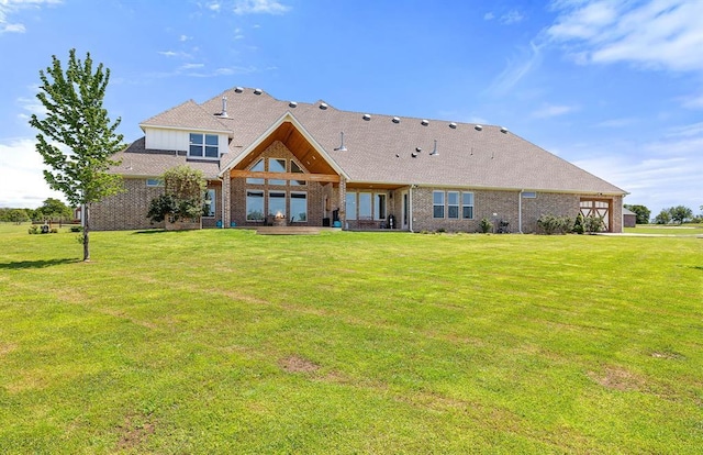 back of property with a patio, brick siding, and a lawn