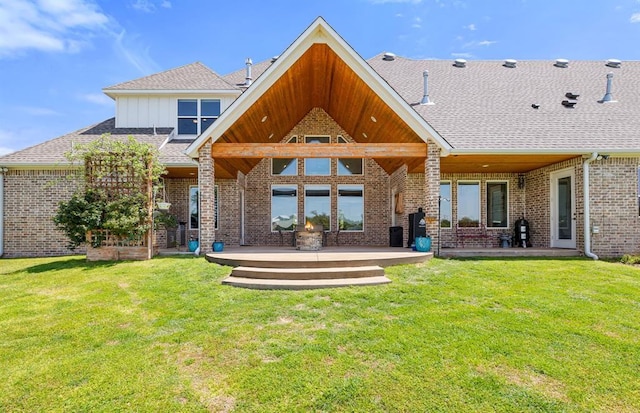 rear view of property with a yard, a patio, and brick siding