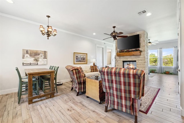 living room featuring visible vents, baseboards, ceiling fan with notable chandelier, and ornamental molding