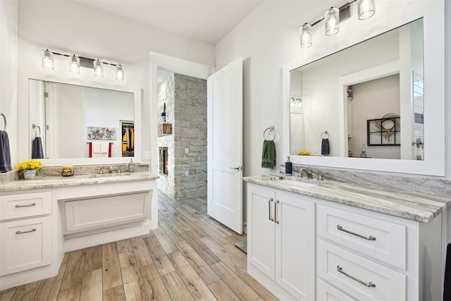 bathroom featuring a sink, two vanities, and wood finished floors