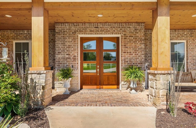 doorway to property featuring brick siding and french doors