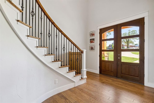 foyer featuring stairway, baseboards, french doors, and wood finished floors