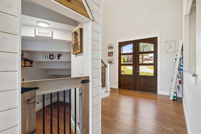 foyer with french doors, wood finished floors, and baseboards