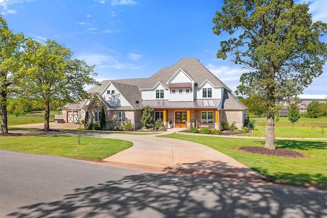 view of front of house featuring a front yard, a standing seam roof, covered porch, and board and batten siding