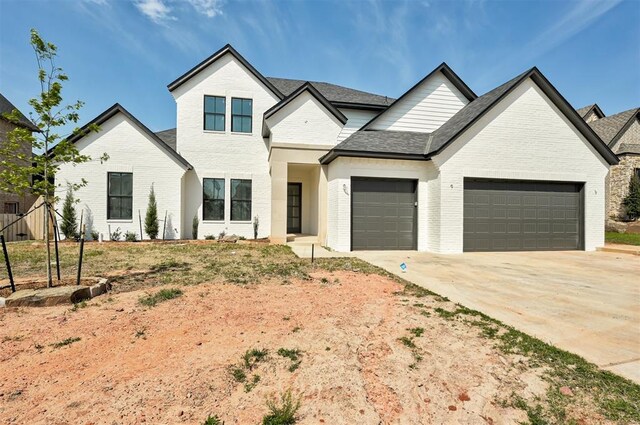 3825 Stone Hill Ln, Edmond, OK 73034 - view of front facade with brick siding, an attached garage, and driveway