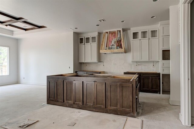 3825 Stone Hill Ln, Edmond, OK 73034 - kitchen featuring wall chimney range hood, concrete floors, a center island, and glass insert cabinets