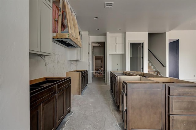 3825 Stone Hill Ln, Edmond, OK 73034 - kitchen with concrete flooring, dark brown cabinets, visible vents, and a center island