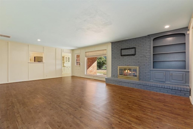 12600 Green Valley Dr, Oklahoma City, OK 73120 - unfurnished living room with visible vents, recessed lighting, built in features, wood finished floors, and a brick fireplace
