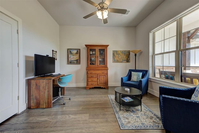 office featuring wood finished floors, visible vents, a ceiling fan, and baseboards