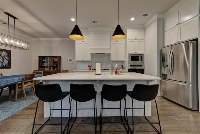 kitchen featuring white cabinets, light wood-style flooring, visible vents, crown molding, and appliances with stainless steel finishes