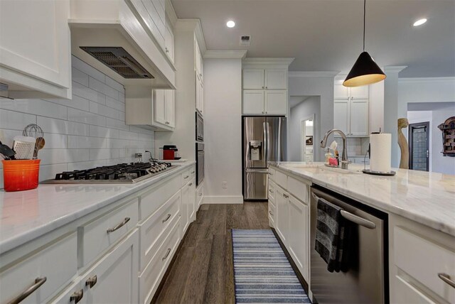 kitchen featuring white cabinets, stainless steel appliances, a sink, custom exhaust hood, and ornamental molding