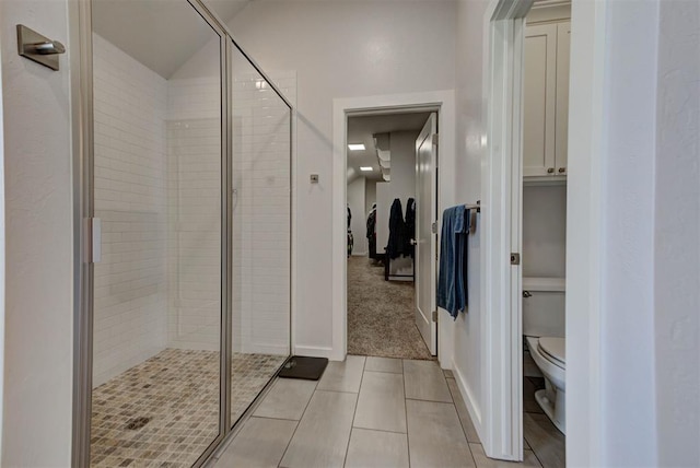 full bathroom with a shower stall, toilet, lofted ceiling, and tile patterned floors
