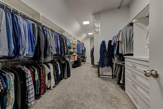 spacious closet featuring lofted ceiling and light colored carpet