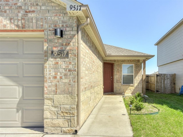 property entrance with an attached garage, brick siding, and roof with shingles