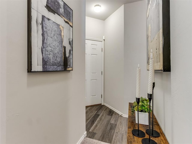 hallway with wood finished floors and baseboards