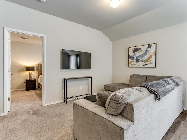 living room featuring baseboards, vaulted ceiling, and light carpet