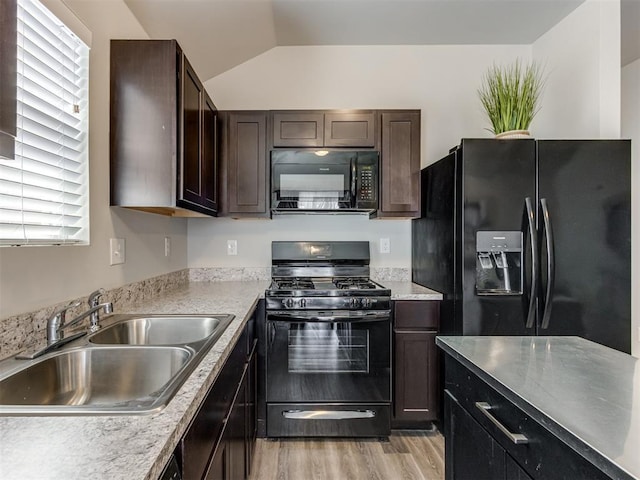kitchen with black appliances, a sink, light wood-type flooring, dark brown cabinetry, and healthy amount of natural light