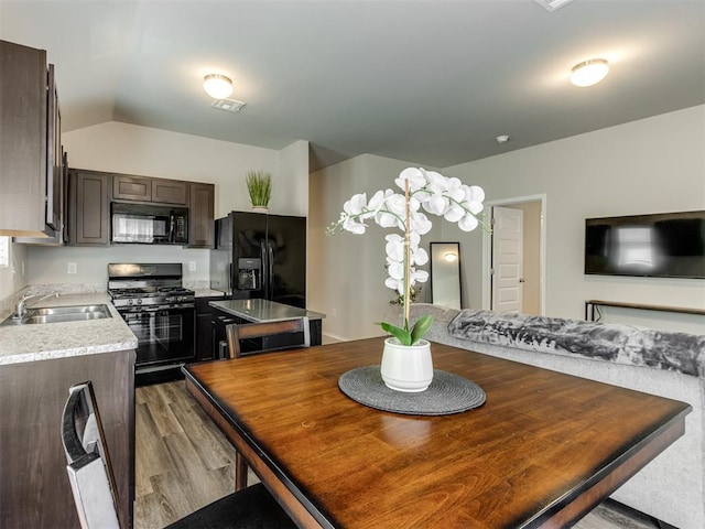 dining area with wood finished floors and lofted ceiling
